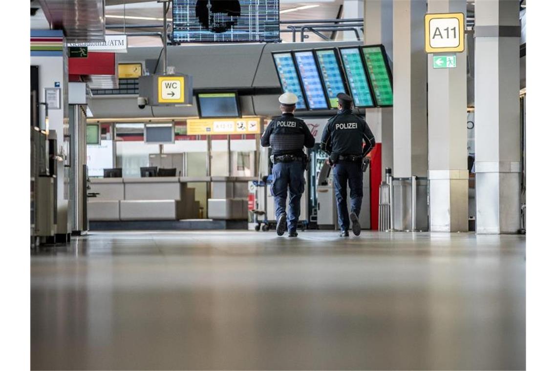 Polizisten patrouillieren am Flughafen Berlin-Tegel durch das Terminal. Foto: Michael Kappeler/dpa
