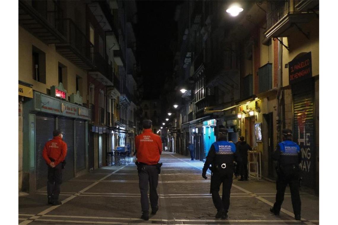 Polizisten patrouillieren auf einer Straße in Pamplona, bevor alle Bars und Restaurants um 22 Uhr geschlossen werden. Seit Mitternacht gelten deutsche Reisewarnungen für weitere Regionen in 15 EU-Ländern. Foto: Alvaro Barrientos/AP/dpa