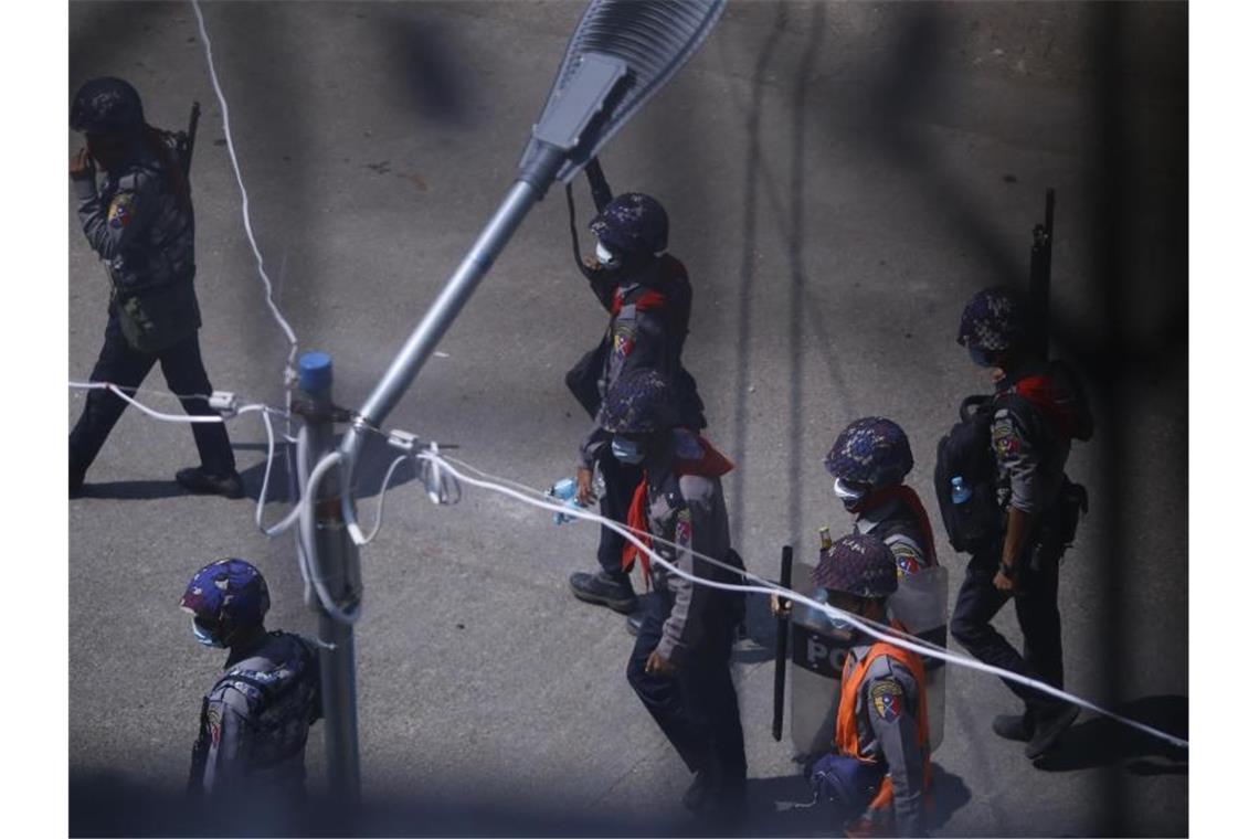 Nach Militärputsch in Myanmar: Schon mehr als 220 Tote Polizisten patrouillieren schwer bewaffnet auf einer Straße. Foto: Uncredited/AP/dpa