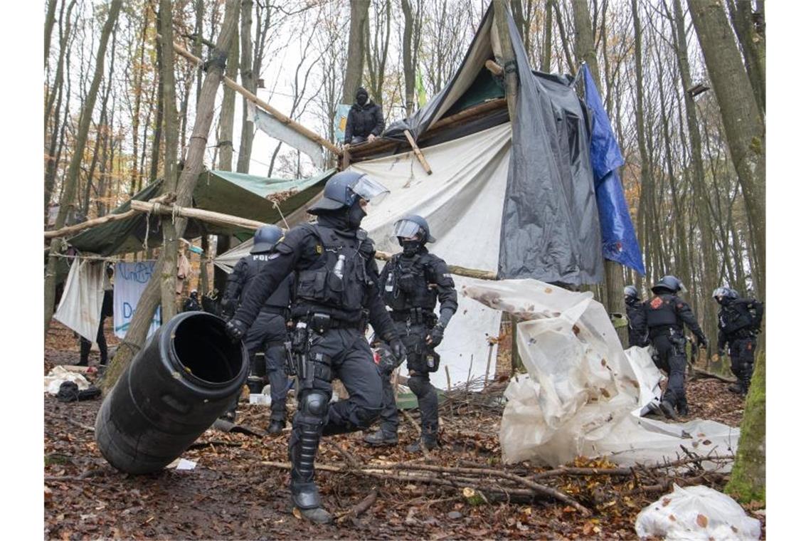 Polizisten räumen in einem Protest-Camp im Dannenröder Forst Gegenstände aus dem Weg. Foto: Boris Roessler/dpa
