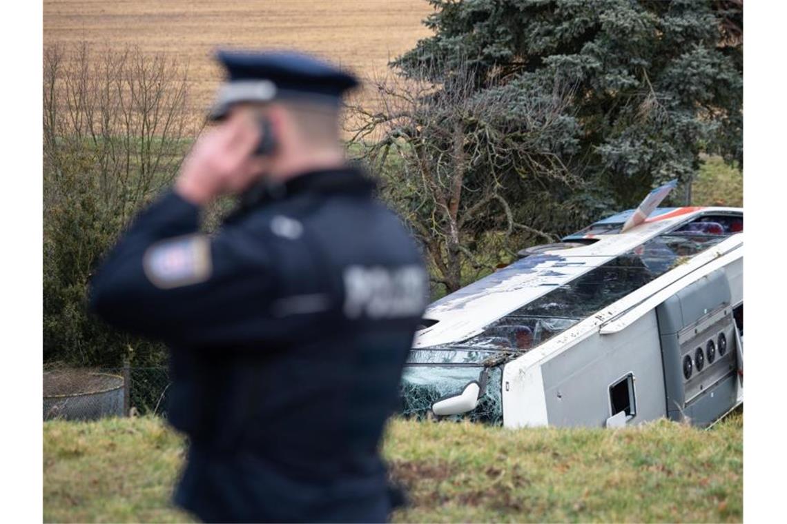 Zwei Kinder sterben bei schwerem Schulbusunfall in Thüringen Polizisten regeln an dem verunglückten Schulbus den Rettungseinsatz. Foto: Swen Pförtner/dpa