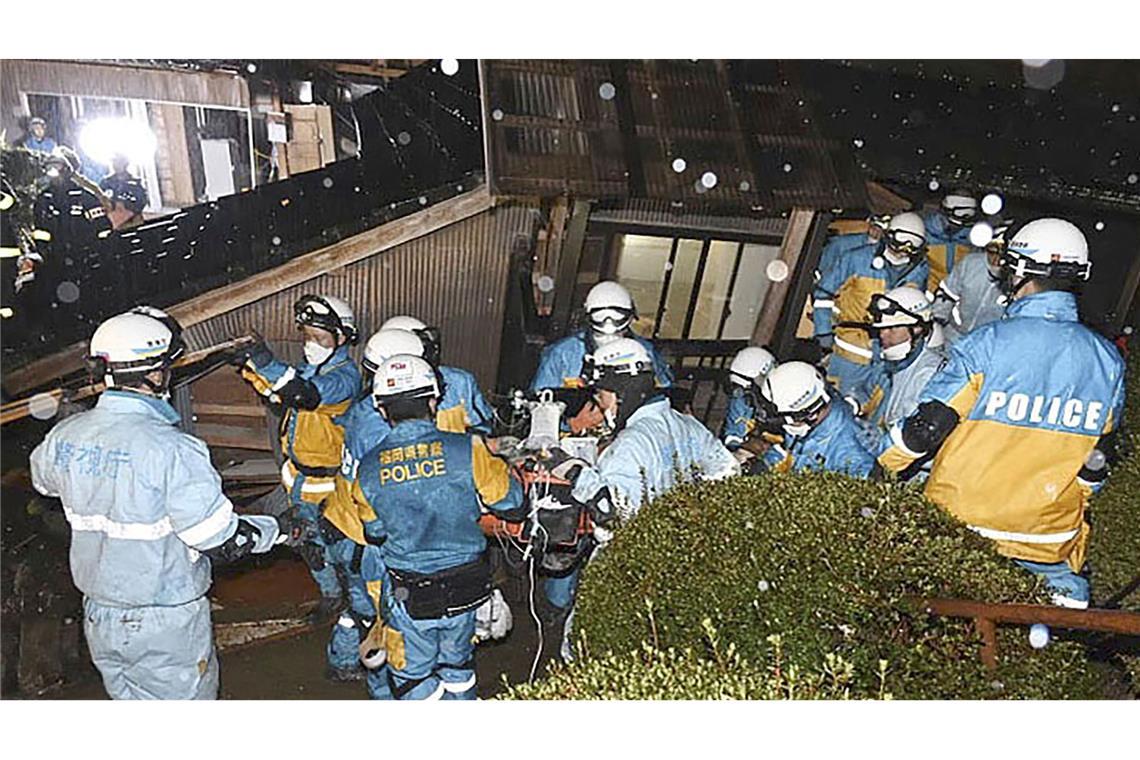 Polizisten retten im japanischen Suzu eine Frau aus einem eingestürzten Haus.