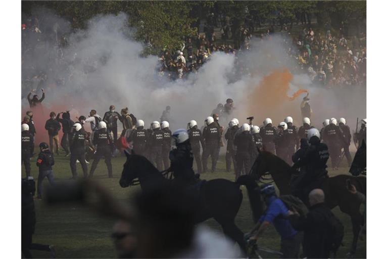 Polizisten setzen Tränengas gegen Demonstranten ein. Foto: Olivier Matthys/AP/dpa