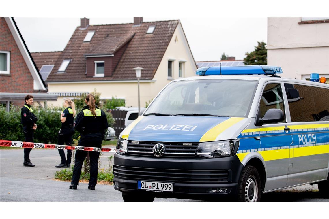 Vier Tote bei Gewalttat – "Oldenburg trauert" Polizisten sperren den Tatort mit Absperrband und Polizeiautos ab.