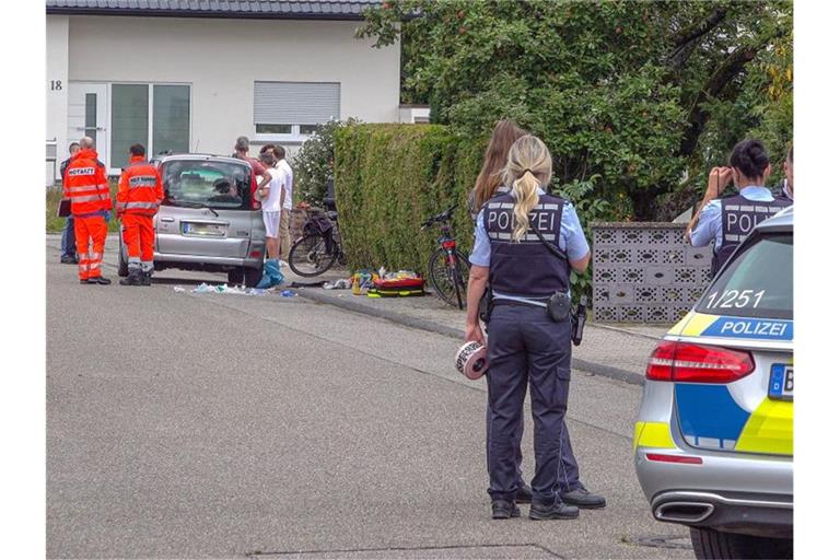 Polizisten sperren eine Straße ab, in der Rettungssanitäter neben einem PKW stehen. Foto: Fabian Geier/dpa/Archivbild