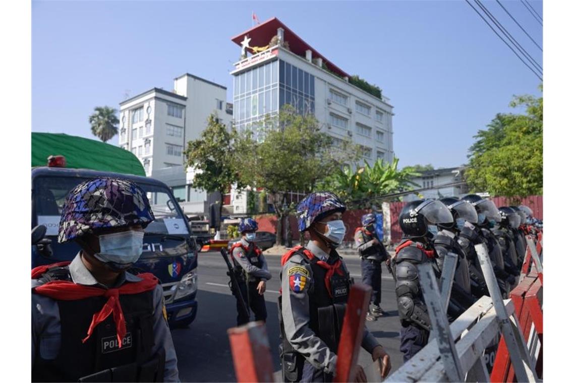 Polizisten sperren eine Straße in Rangun. Zahlreiche Menschen demonstrieren gegen den Militärputsch. Foto: Thet Htoo/ZUMA Wire/dpa