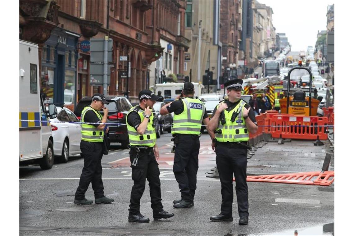 Polizisten stehen am abgesperrten Tatort in der West George Street in Glasgow. Foto: Andrew Milligan/PA Wire/dpa