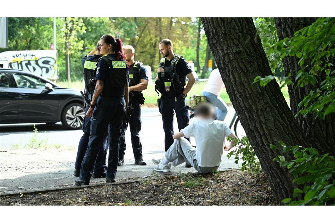 Auto fährt in Berlin in Kindergruppe - Fahrer festgenommen Polizisten stehen an der Unfallstelle.