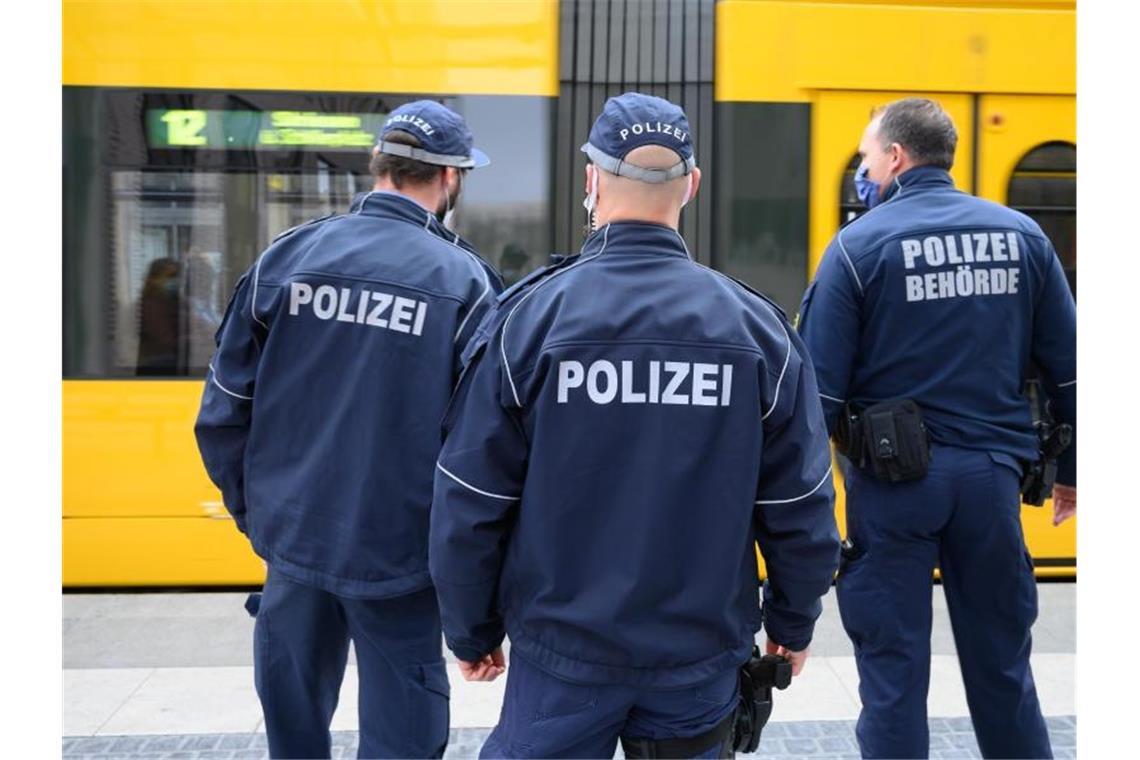 Polizisten stehen an einer Straßenbahn-Haltestelle. Foto: Sebastian Kahnert/dpa-Zentralbild/dpa/Symbolbild