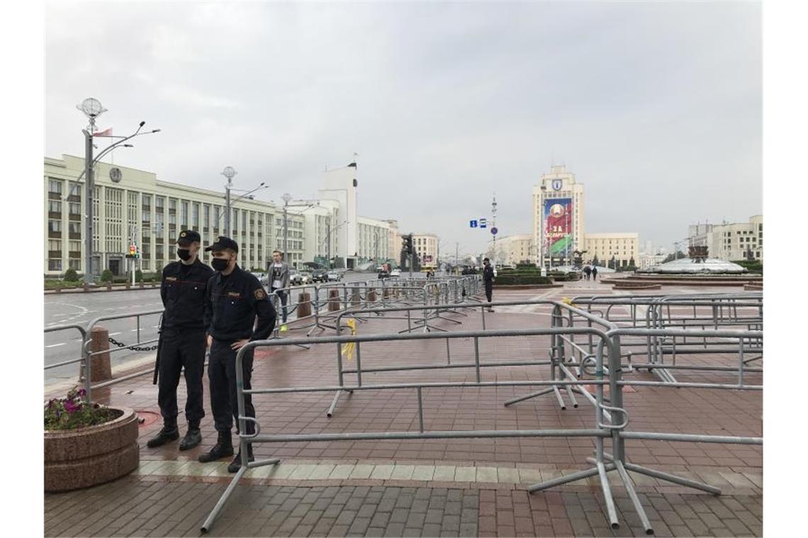 Polizisten stehen an Metallgittern auf dem abgeriegelten Unabhängigkeitsplatz vor der geplanten großen Sonntagsdemonstration gegen den umstrittenen belarussischen Staatschef Lukaschenko. Foto: Ulf Mauder/dpa