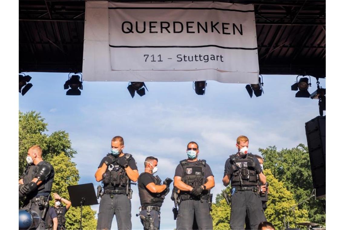 „Querdenker“ im Visier des Verfassungsschutzes Polizisten stehen bei einer Kundgebung gegen die Corona-Beschränkungen auf der Straße des 17. Juni in Berlin auf der Bühne unter dem Banner der Initiative „Querdenken 711“. Die Polizei hatte die Veranstaltung aufgelöst. Foto: Christoph Soeder/dpa