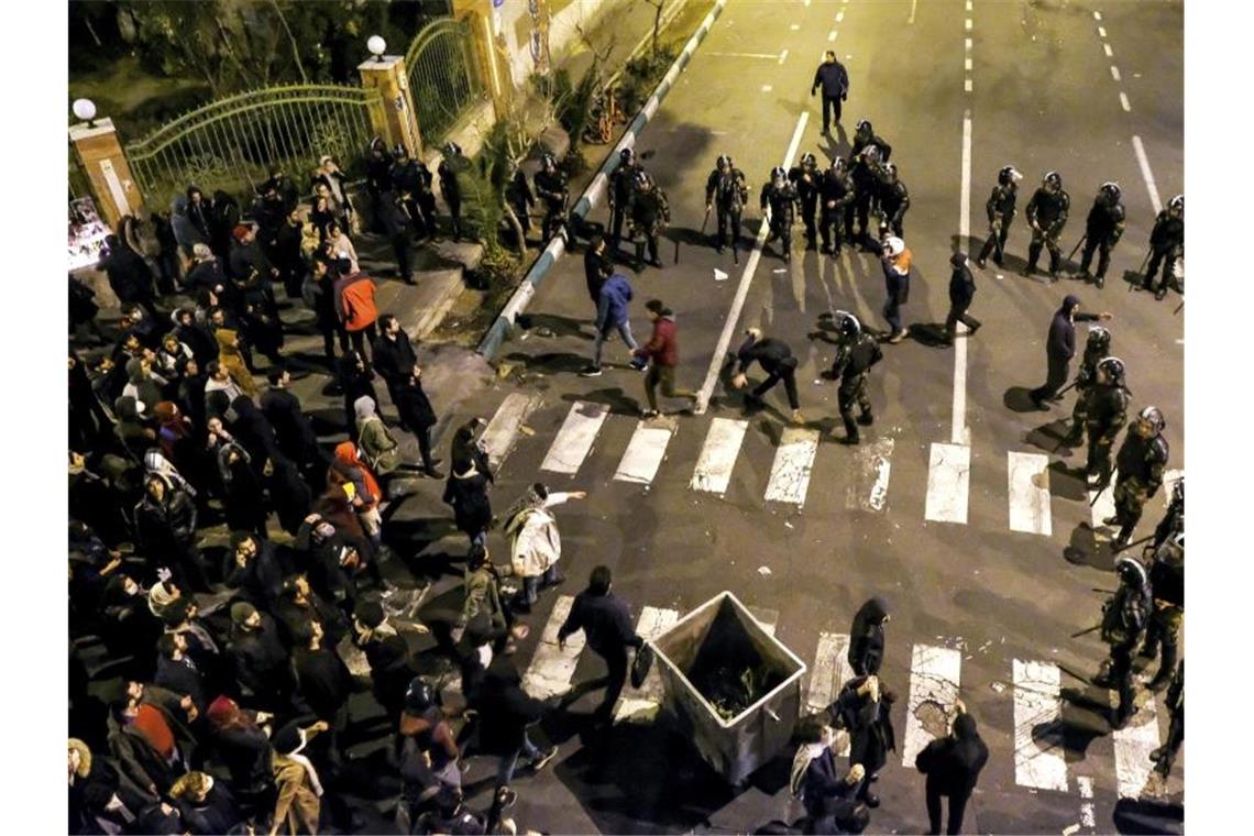 Trump: Keine Unstimmigkeiten über Tötung Soleimanis Polizisten stehen Demonstranten vor einer Universität in Teheran gegenüber. Foto: AP/dpa