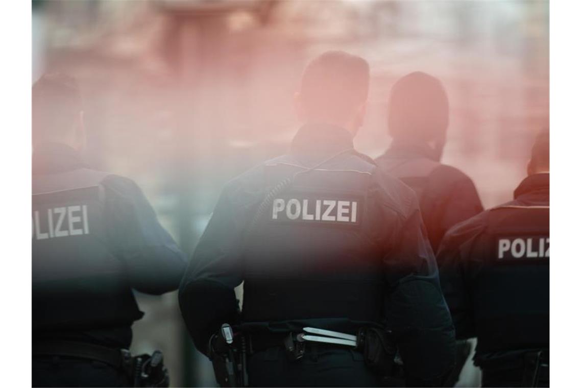 Razzia gegen illegale Millionentransfers: 27 Beschuldigte Polizisten stehen hinter einem Absperrband. Foto: Klaus-Dietmar Gabbert/zb/dpa/Archivbild