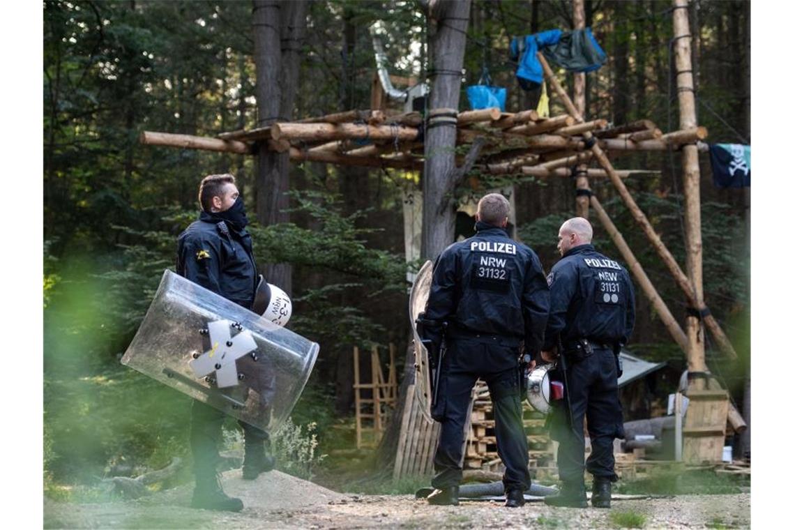 Polizisten stehen im Hambacher Forst vor einer von Umweltaktivisten gebauten Plattform. Foto: Marius Becker/dpa
