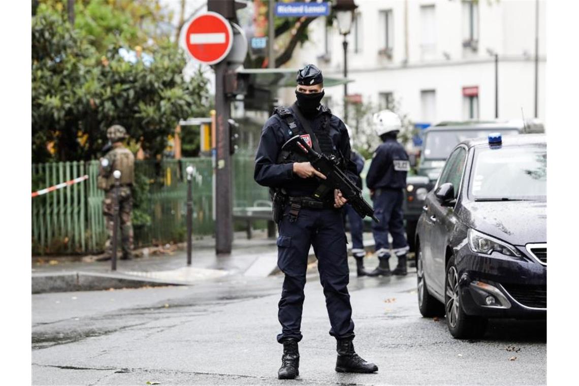 Polizisten stehen in der Nähe des Tatorts. Foto: Lewis Joly/AP/dpa