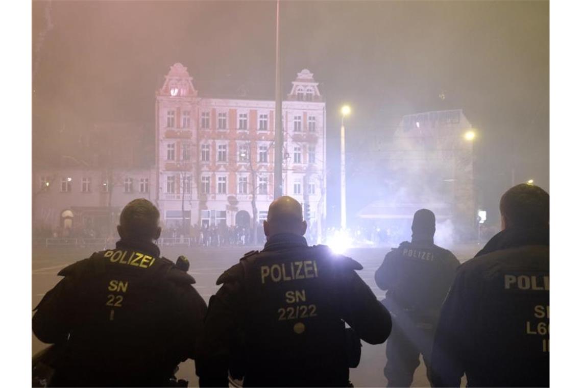 Polizisten stehen in der Neujahrsnacht an einer Kreuzung im Leipziger Stadtteil Connewitz. Foto: Sebastian Willnow/dpa-Zentralbild/dpa