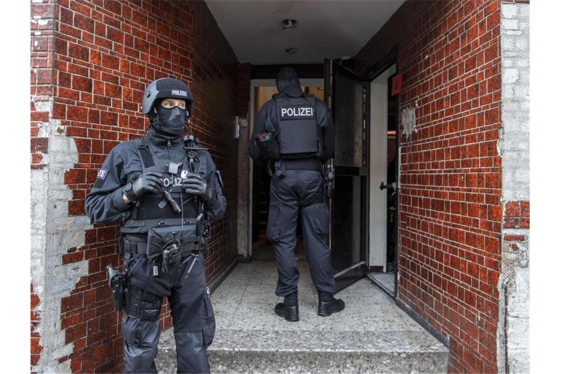 Razzia im Duisburger Clan-Milieu: Mehrere Festnahmen Polizisten stehen in einem Hauseingang im Stadtteil Laar. Foto: Christoph Reichwein/dpa