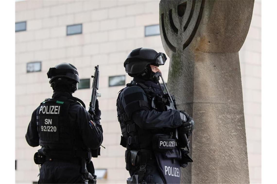 Polizisten stehen mit automatischen Waffen vor einer Synagoge. Foto: Robert Michael/dpa-Zentralbild/dpa