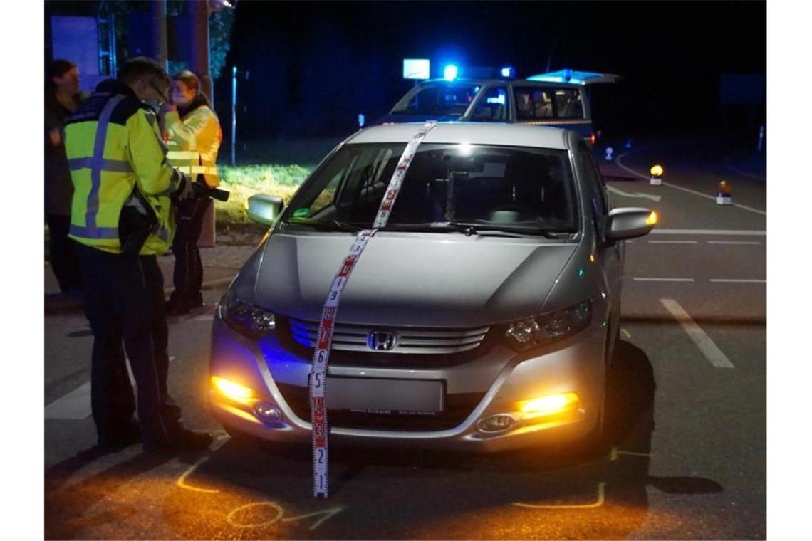 Polizisten stehen nach einem Unfall an einem Honda. Foto: Boehmler/SDMG/dpa