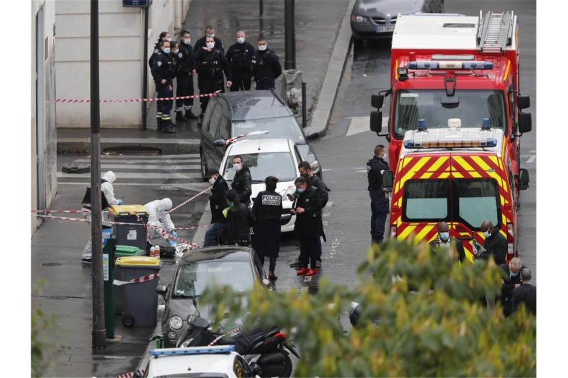 Messerattacke vor „Charlie-Hebdo“-Gebäude erschüttert Paris Polizisten stehen neben der Absperrung des Tatortes. Foto: Thibault Camus/AP/dpa