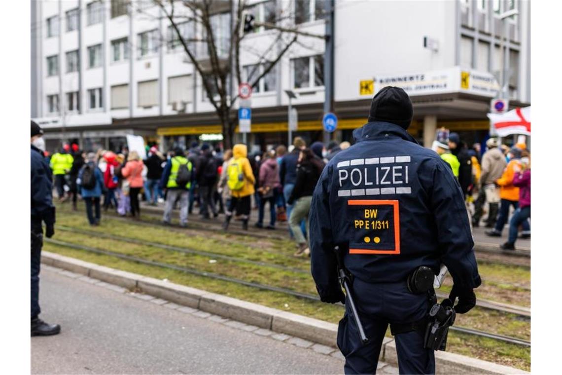 Wieder Demos pro und kontra Corona-Politik erwartet Polizisten stehen neben Teilnehmern einer Demonstration gegen die Corona-Maßnahmen. Foto: Philipp von Ditfurth/dpa/Archivbild