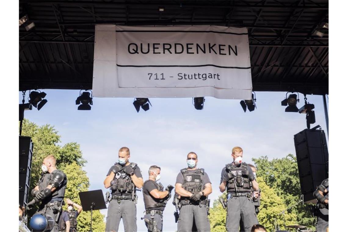 Polizisten stehen unter einem Banner der Initiative „Querdenken 711“. Foto: Christoph Soeder/dpa/Archivbild