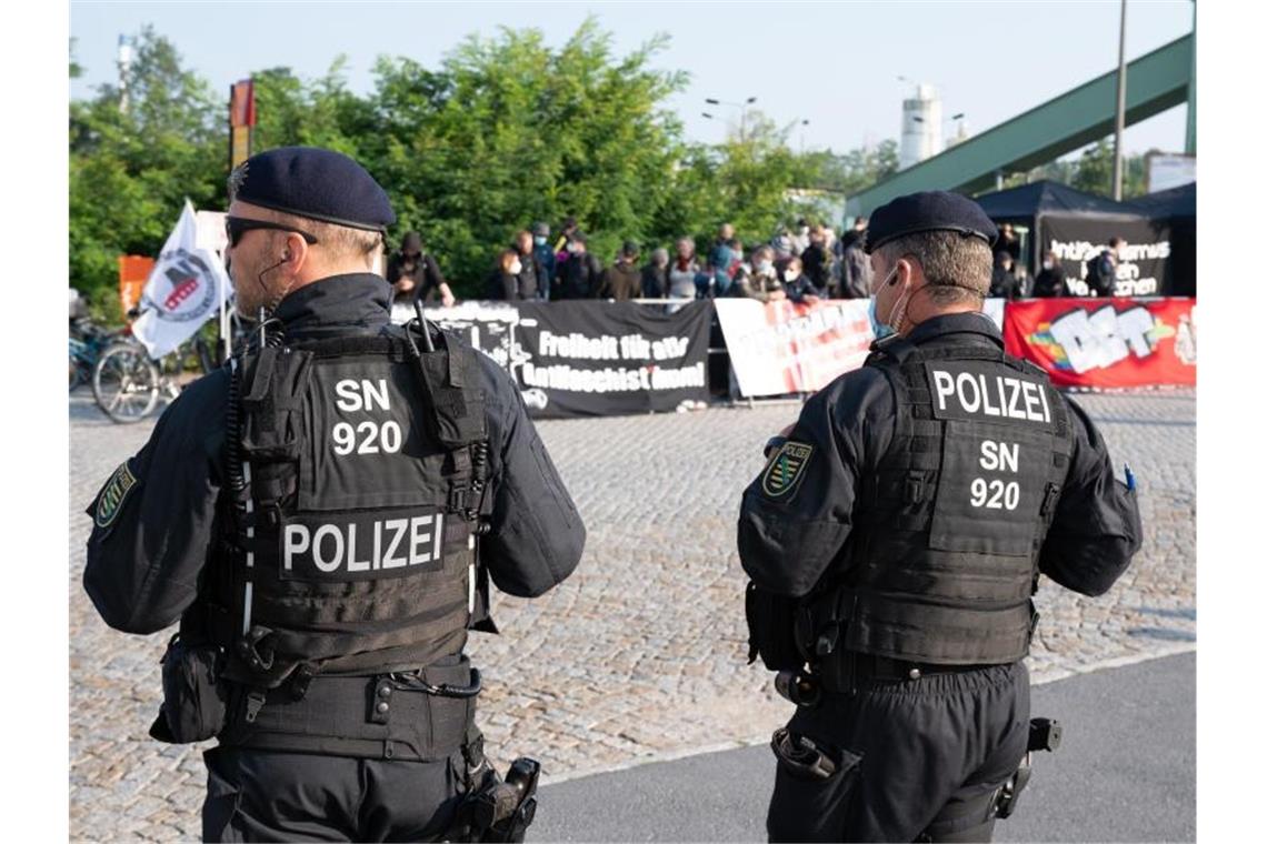 Polizisten stehen vor Beginn des Prozesses vor dem Oberlandesgericht Dresden Demonstranten gegenüber, die sich mit den Angeklagten solidarisieren. Foto: Sebastian Kahnert/dpa-Zentralbild/dpa