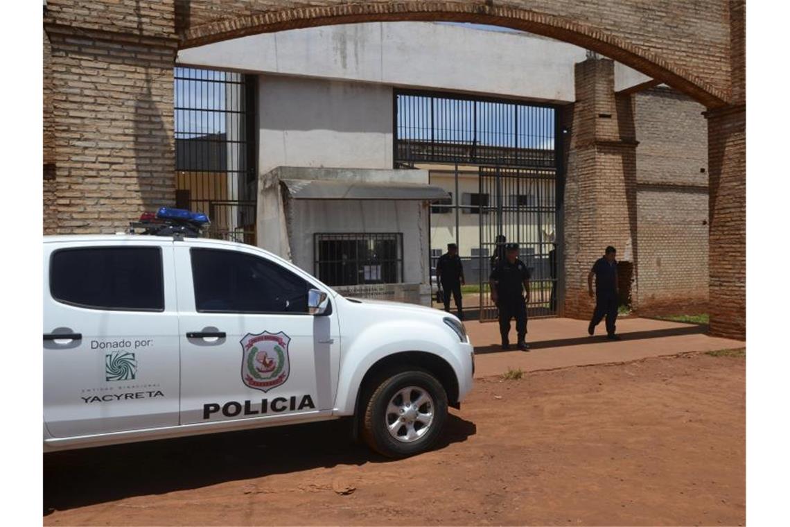 Polizisten stehen vor dem Eingang des Gefängnisses in Paraguay, aus dem bei einem Massenausbruch 75 Häftlinge getürmt sind. Foto: Marciano Candia/AP/dpa
