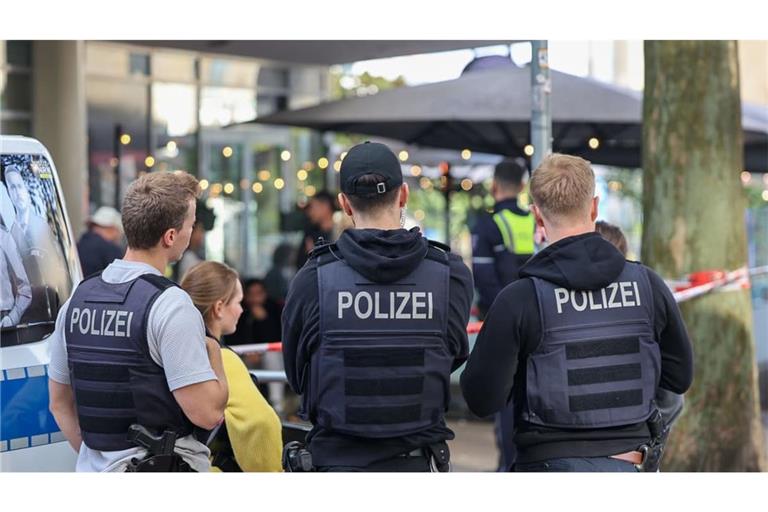 Polizisten stehen vor einem Absperrband. Zwei Unbekannte haben mitten in Essen zwei Justizbeamte angegriffen und einen 34 Jahre alten Häftling befreit. Die beiden Justizbediensteten, die den Gefangenen in eine Arztpraxis bringen sollten, wurden nach Informationen der Deutschen Presse-Agentur überwältigt und gefesselt.