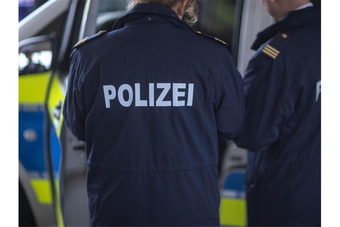 Polizisten stehen vor einem Polizeifahrzeug. Foto: Jens Büttner/dpa-Zentralbild/ZB/Symbolbild