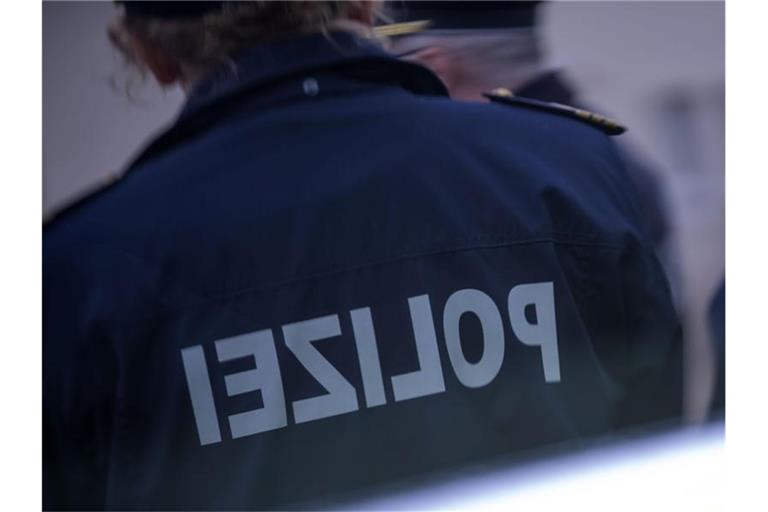 Polizisten stehen vor einem Polizeifahrzeug. Foto: Jens Büttner/dpa-Zentralbild/ZB/Symbolbild