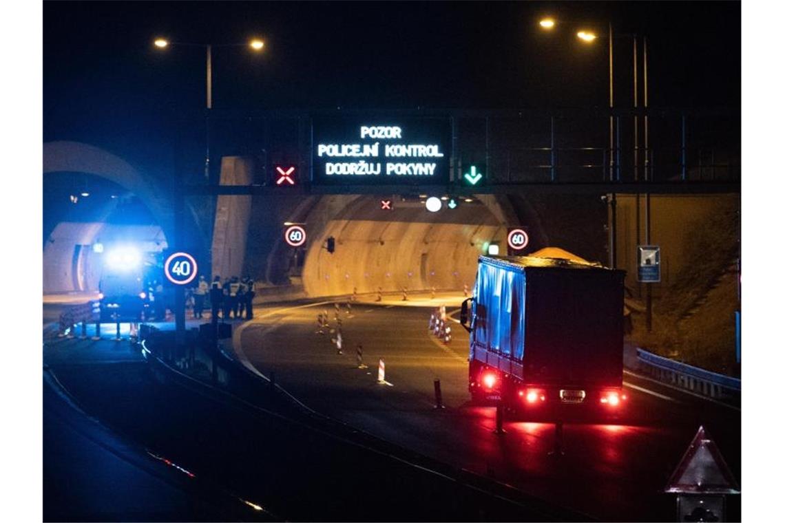 Polizisten stehen vor einem Tunnel auf der Autobahn D8 Dresden - Prag. Tschechien schließt seine Grenzen weitgehend für Ausländer aus mehreren europäischen Ländern. Foto: Sebastian Kahnert/dpa-Zentralbild/dpa