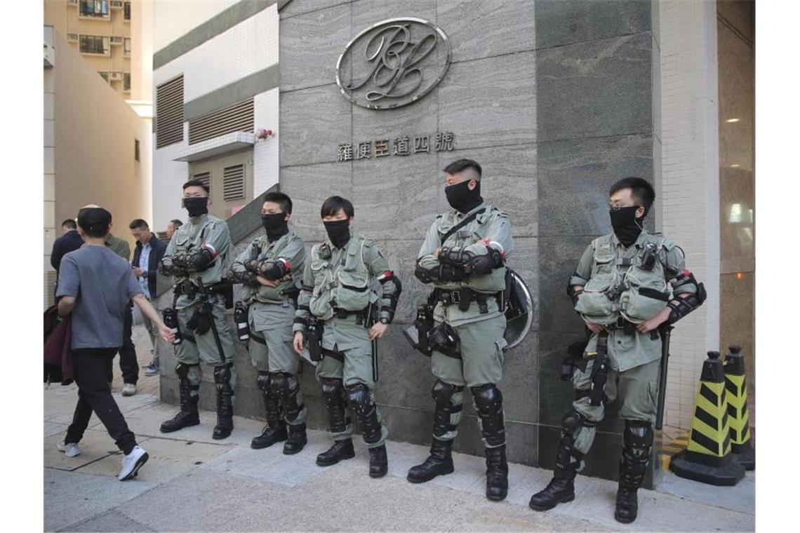 Polizisten stehen vor einem Wahllokal in Hongkong. Foto: Kin Cheung/AP/dpa