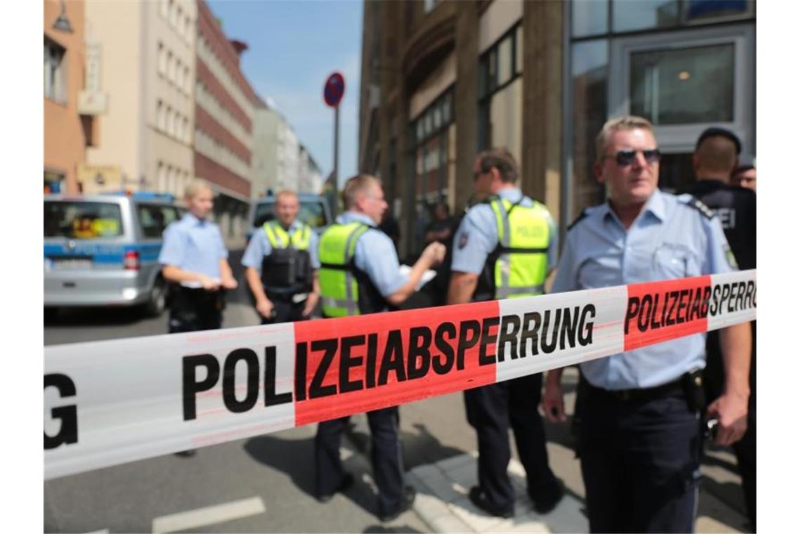 Polizisten stehen vor einem Wohngebäude eines der mutmaßlichen Gefährder in der Kölner Innenstadt hinter einem Absperrband. Foto: Oliver Berg