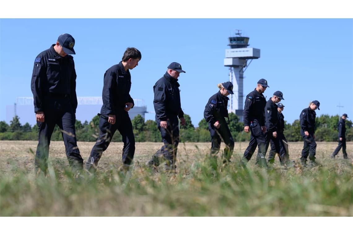 Polizisten suchen nach dem Drohnenvorfall am Flughafen Leipzig nach Drohnenspuren.