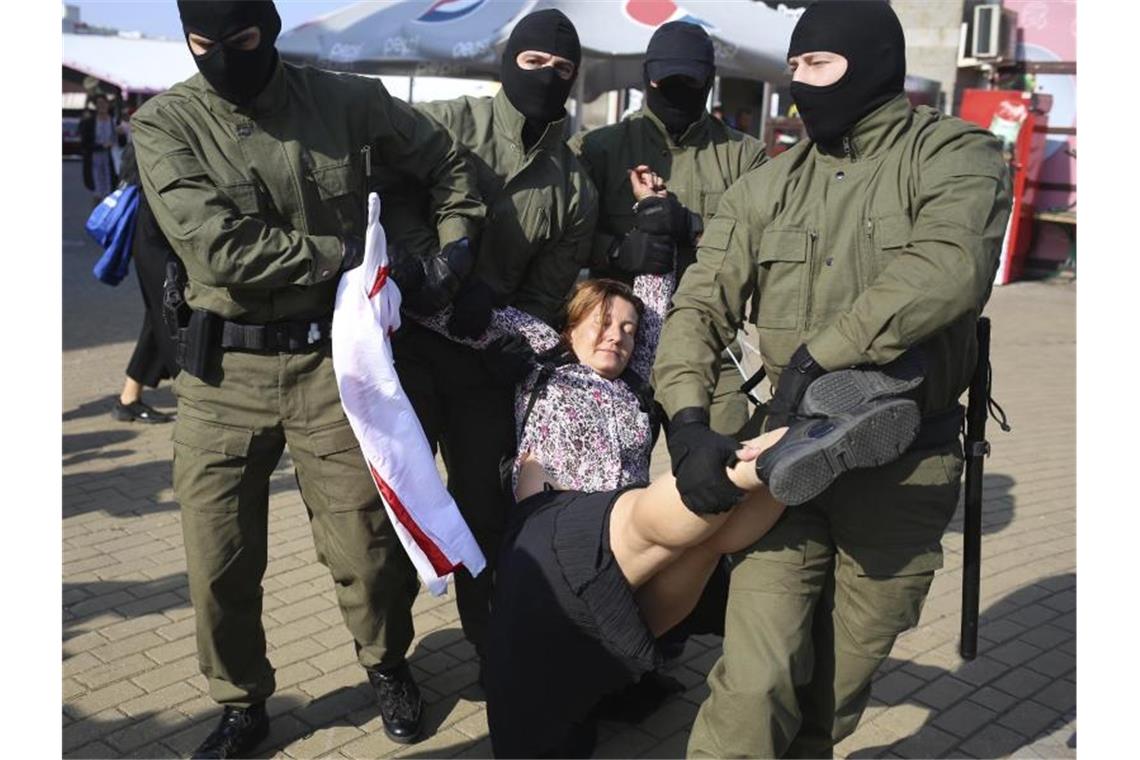 Frauen demonstrieren in Minsk gegen Lukaschenko Polizisten tragen am Rande einer Demonstration in Minsk eine Frau weg. Foto: Uncredited/TUT.by/dpa