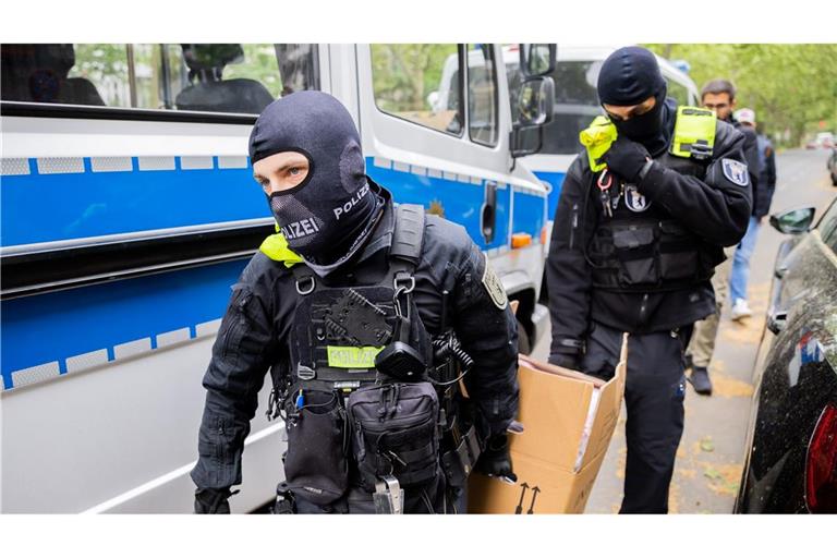 Polizisten tragen bei einer Hausdurchsuchung im Mai 2023 in Berlin-Kreuzberg einen Karton zu einem Fahrzeug.