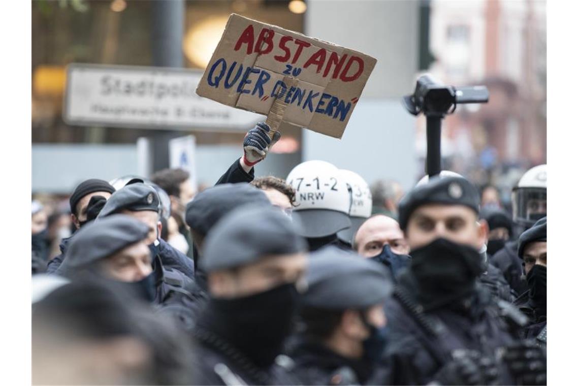 Polizisten trennen an der Hauptwache in Frankfurt/Main Teilnehmer der gerichtlich verbotenen Querdenker-Kundgebung und Gegendemonstranten. Foto: Boris Roessler/dpa