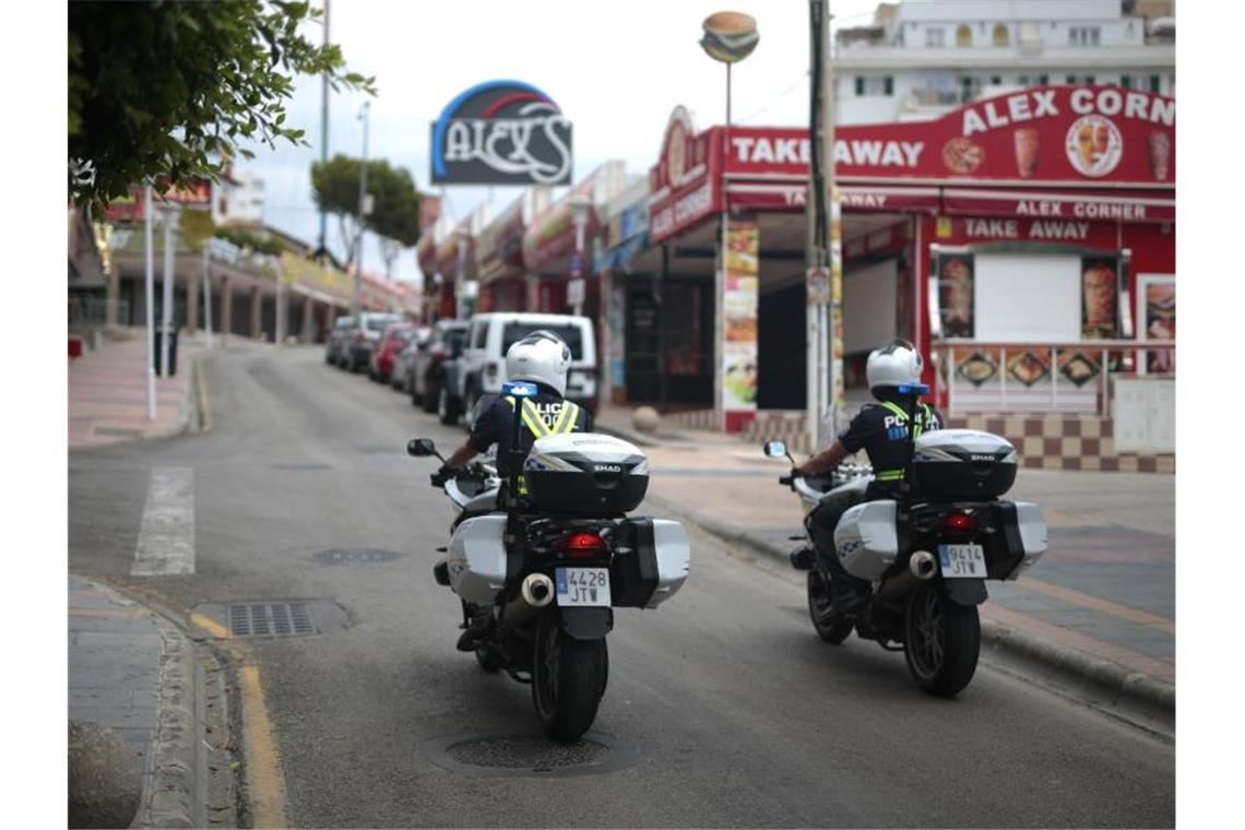 Polizisten überwachen die Lokalsperrungen auf einer Straße in der Touristenhochburg Magaluf. Foto: Joan Mateu/AP/dpa