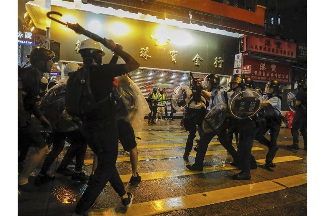 Neue Zusammenstöße in Hongkong - Wasserwerfer auf der Straße Polizisten und Demonstranten stoßen während des Protests aufeinander. Foto: Kin Cheung/AP