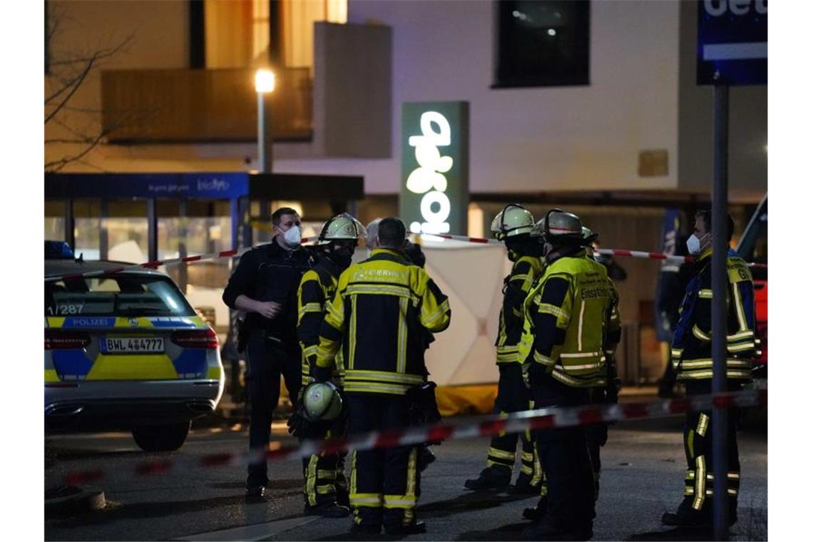 Polizisten und Feuerwehr stehen an einem Supermarkt. Dort sind zwei Menschen durch Schüsse ums Leben gekommen. Foto: Kohls/SDMG/dpa