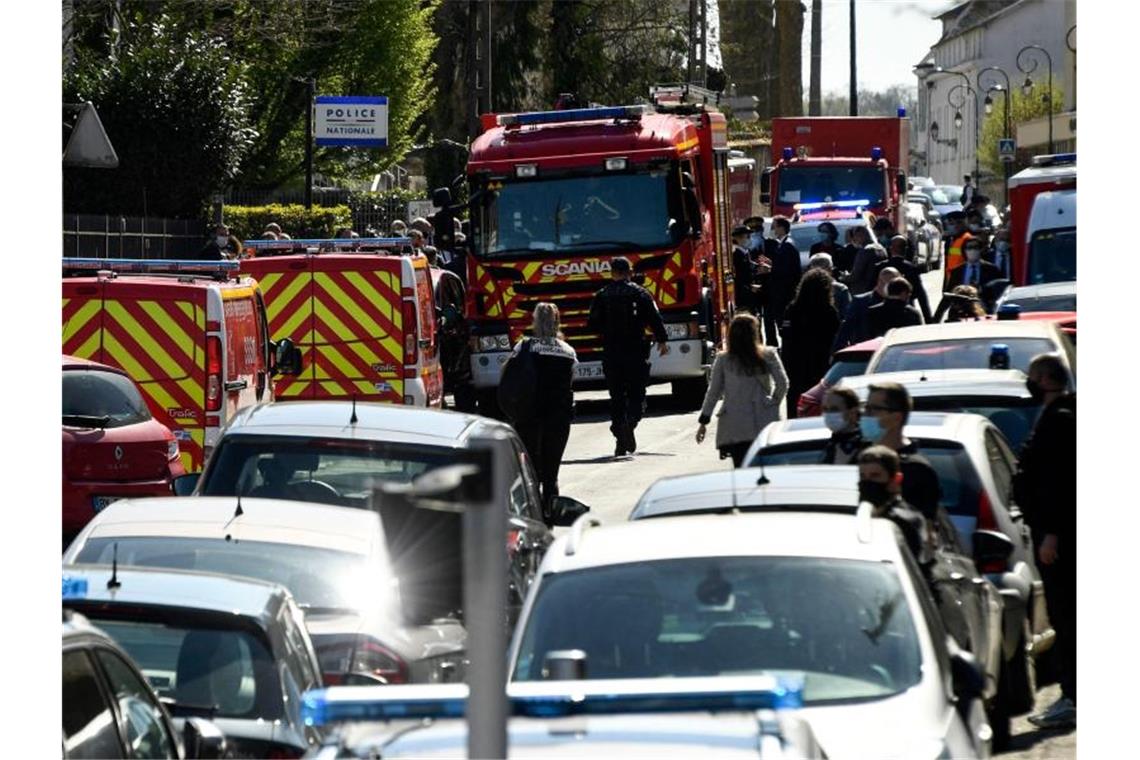 Polizisten und Feuerwehrleute stehen in der Nähe der Polizeistation in Rambouillet. Foto: Bertrand Guay/AFP/dpa