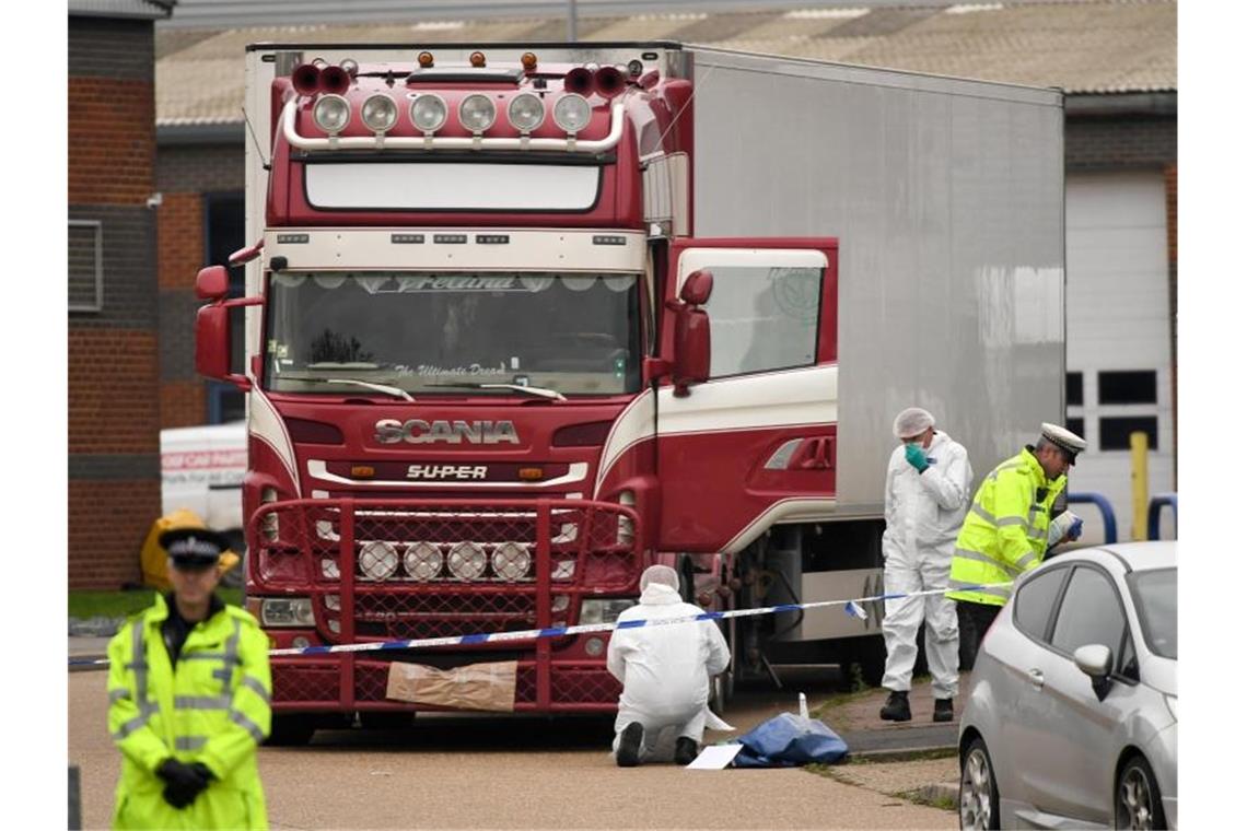 Polizisten und Mitarbeiter der Spurensicherung arbeiten an dem LKW, in dem 39 Leichen gefunden wurden. Foto: Stefan Rousseau/PA Wire/dpa