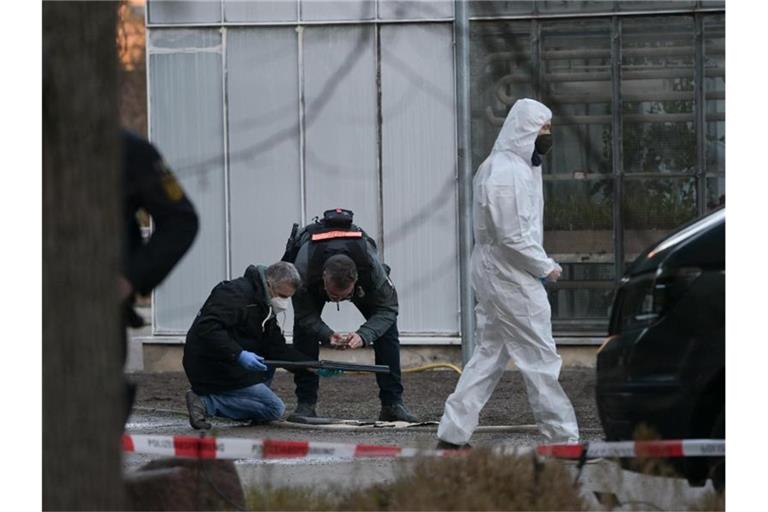 Polizisten untersuchen eine Waffe auf dem Gelände der Heidelberger Universität. Foto: Sebastian Gollnow/dpa