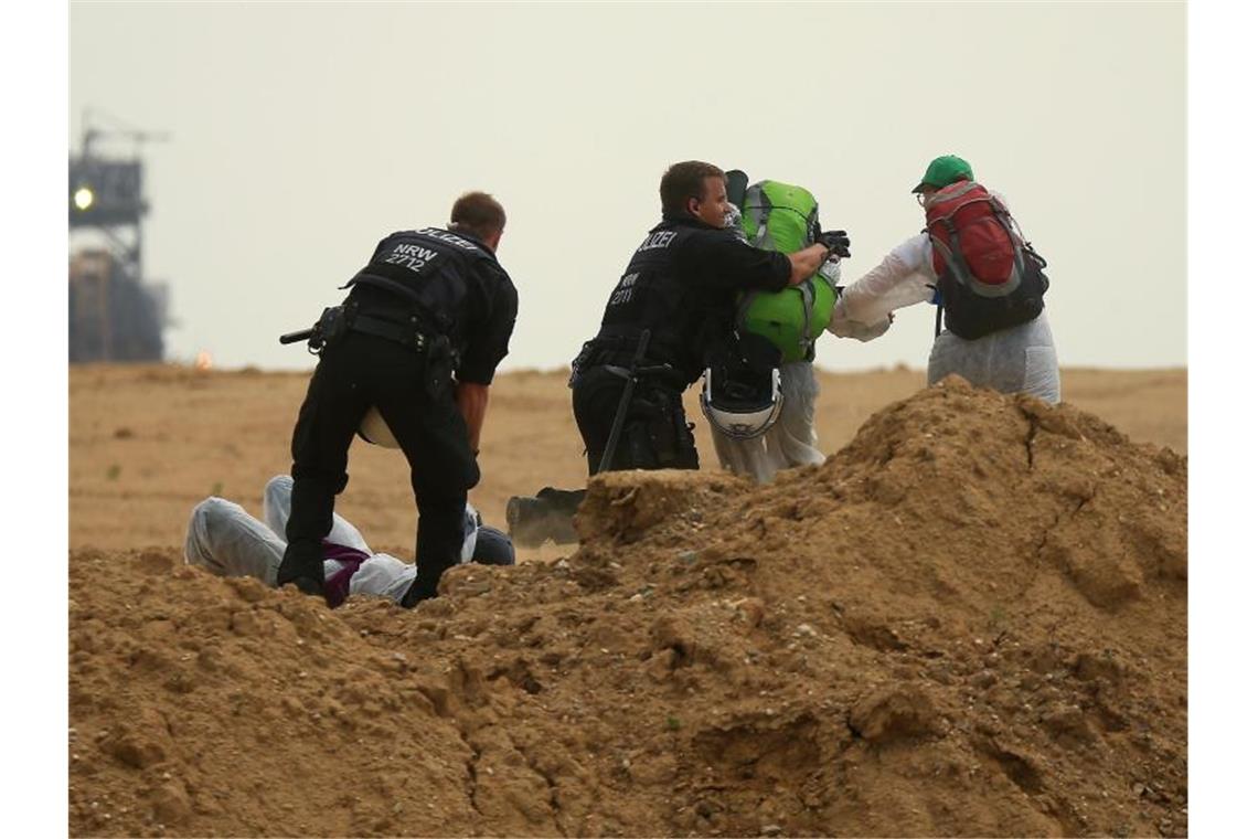 Klimaproteste im Rheinischen Revier nach drei Tagen beendet Polizisten versuchen Aktivisten am Betreten des Tagebau Garzweiler zu hindern. Foto: David Young