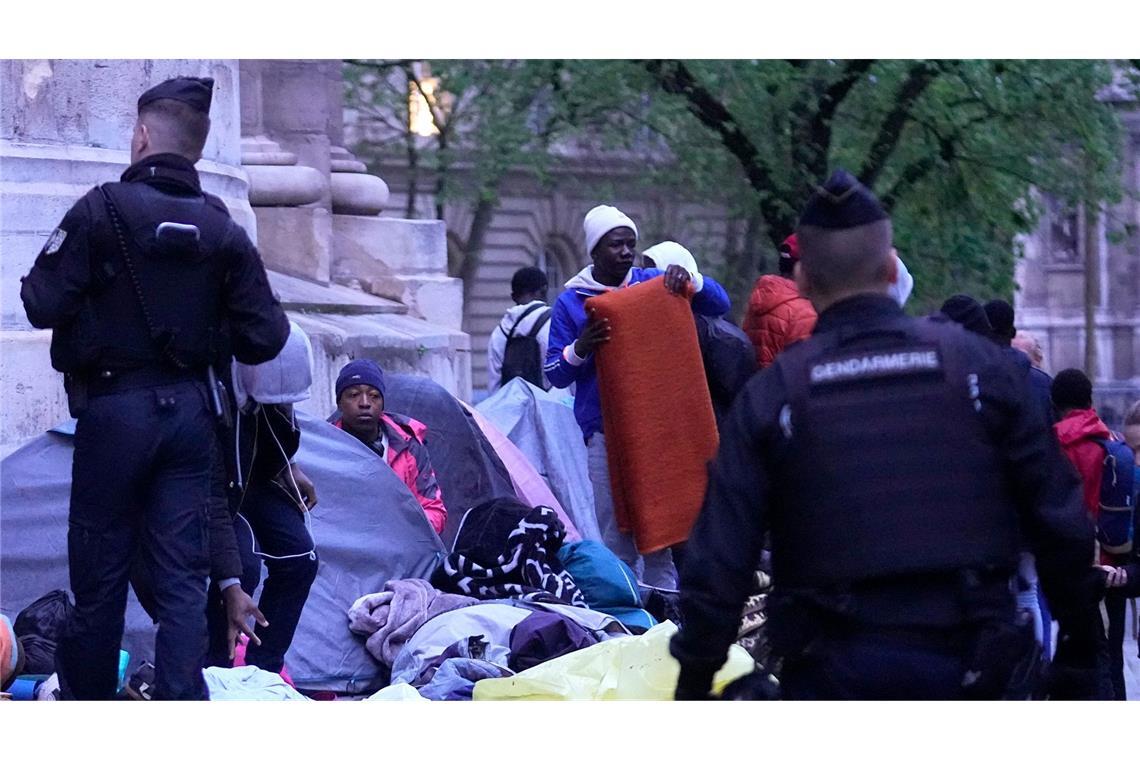 Polizisten vertreiben Migranten aus einem behelfsmäßigen Lager in Paris. Ähnliche Aktionen werden von den Polizeibehörden in den Monaten vor den Olympischen Spielen täglich durchgeführt.