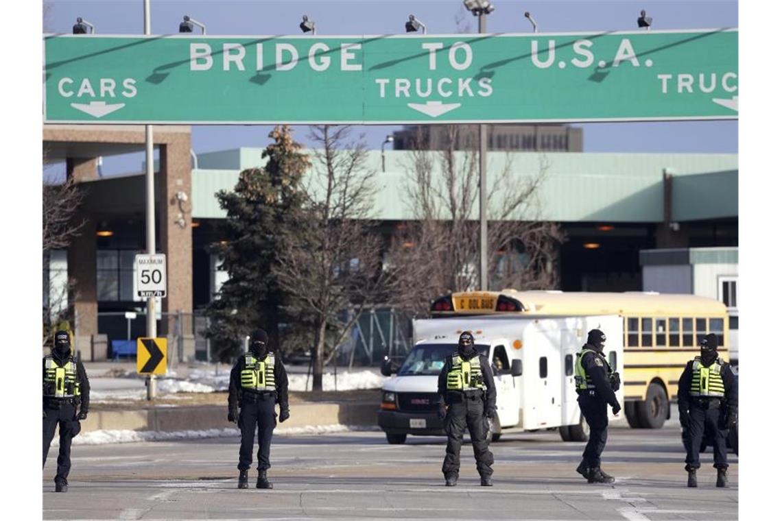 Trucker-Proteste in Kanada: Polizei beginnt mit Auflösung Polizisten vor der Ambassador-Brücke in Windsor. Die kanadische Polizei hat mit der Auflösung von Trucker-Blockaden an einer wichtigen Grenzbrücke zwischen der Stadt Windsor in Kanada und Detroit in den USA begonnen. Foto: Nathan Denette/The Canadian Press/AP/dpa