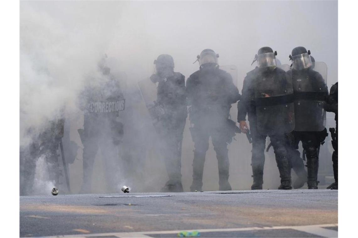 Polizisten während eines Protests in Atlanta inmitten einer Tränengaswolke. Foto: Ben Gray/Atlanta Journal-Constitution/AP/dpa