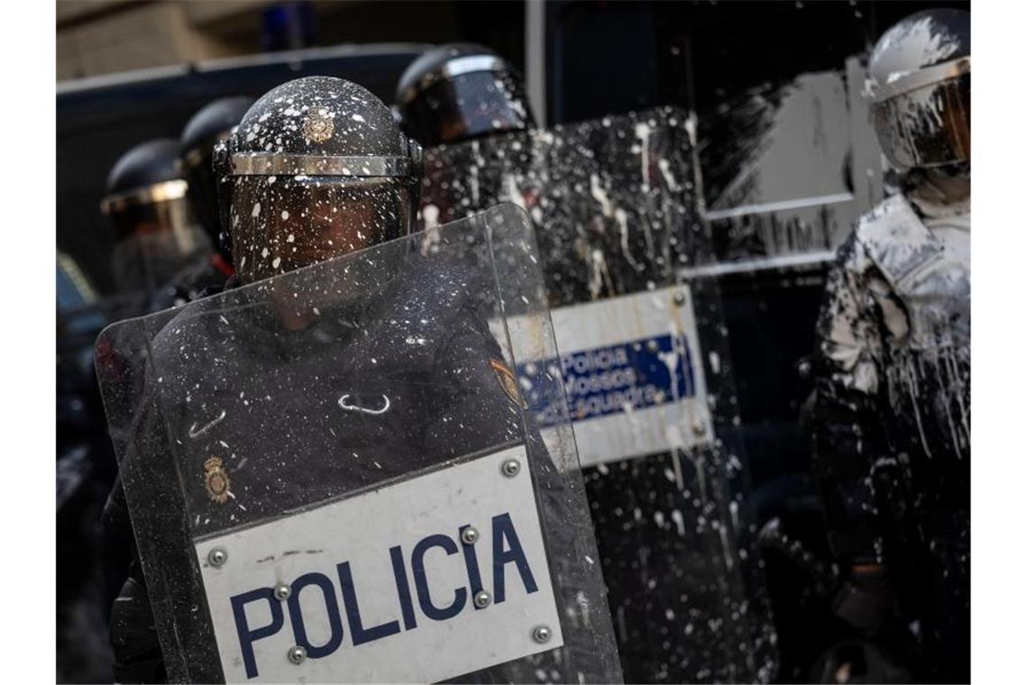 Polizisten wurden von Demonstranten mit Farbe beworfen. Foto: Bernat Armangue/AP/dpa