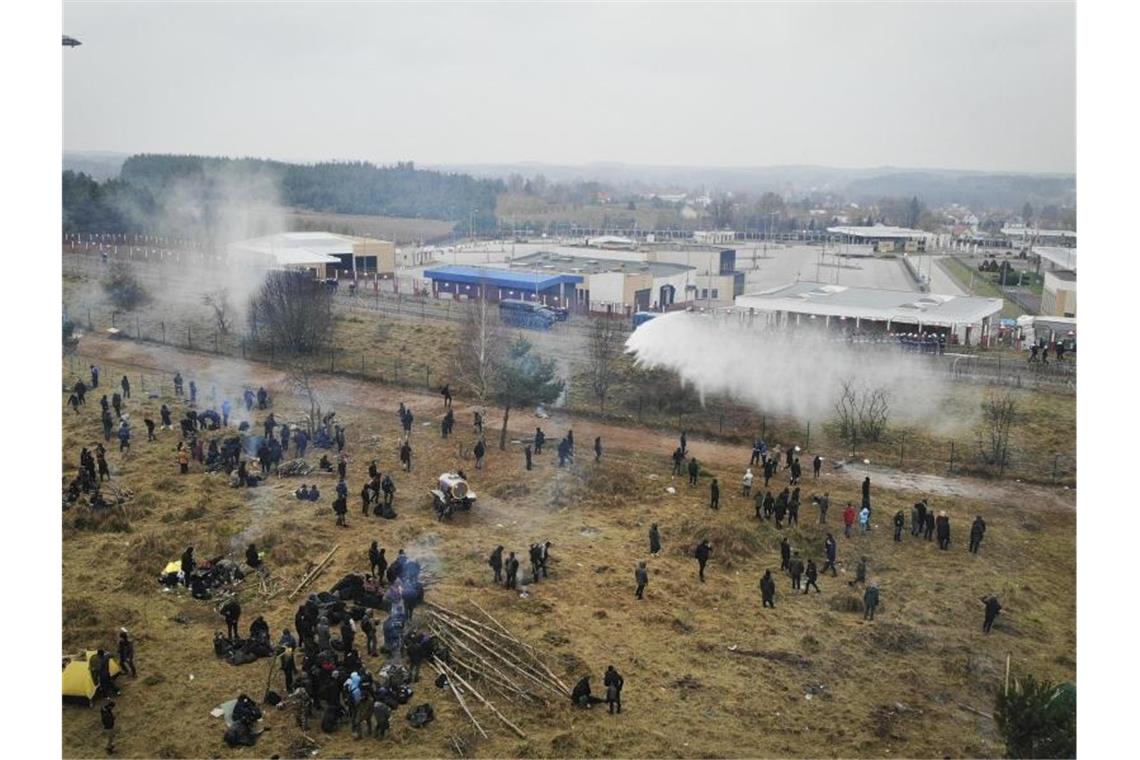 Krise um Migranten an Polens Grenze weiter ungelöst Polnische Grenzsoldaten setzen Wasserwerfer gegen Migranten ein. Foto: Leonid Shcheglov/BelTA/AP/dpa